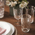 A clear glass with a Victorian-inspired design, featuring intricate embossed patterns and a wide mouth.